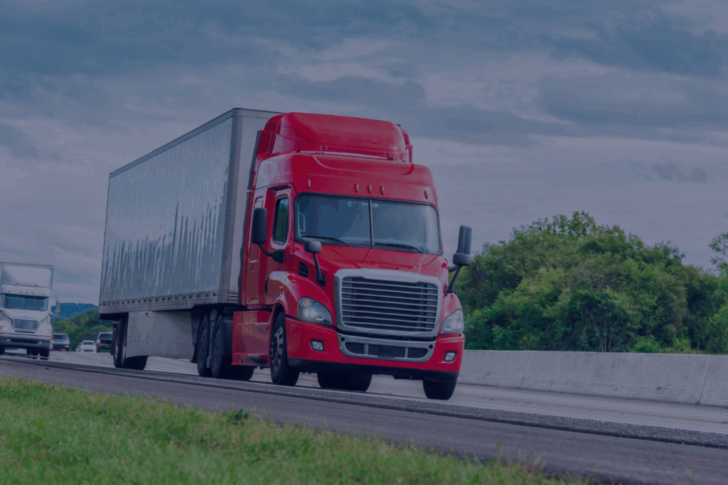 red eighteen wheeler driving on highway
